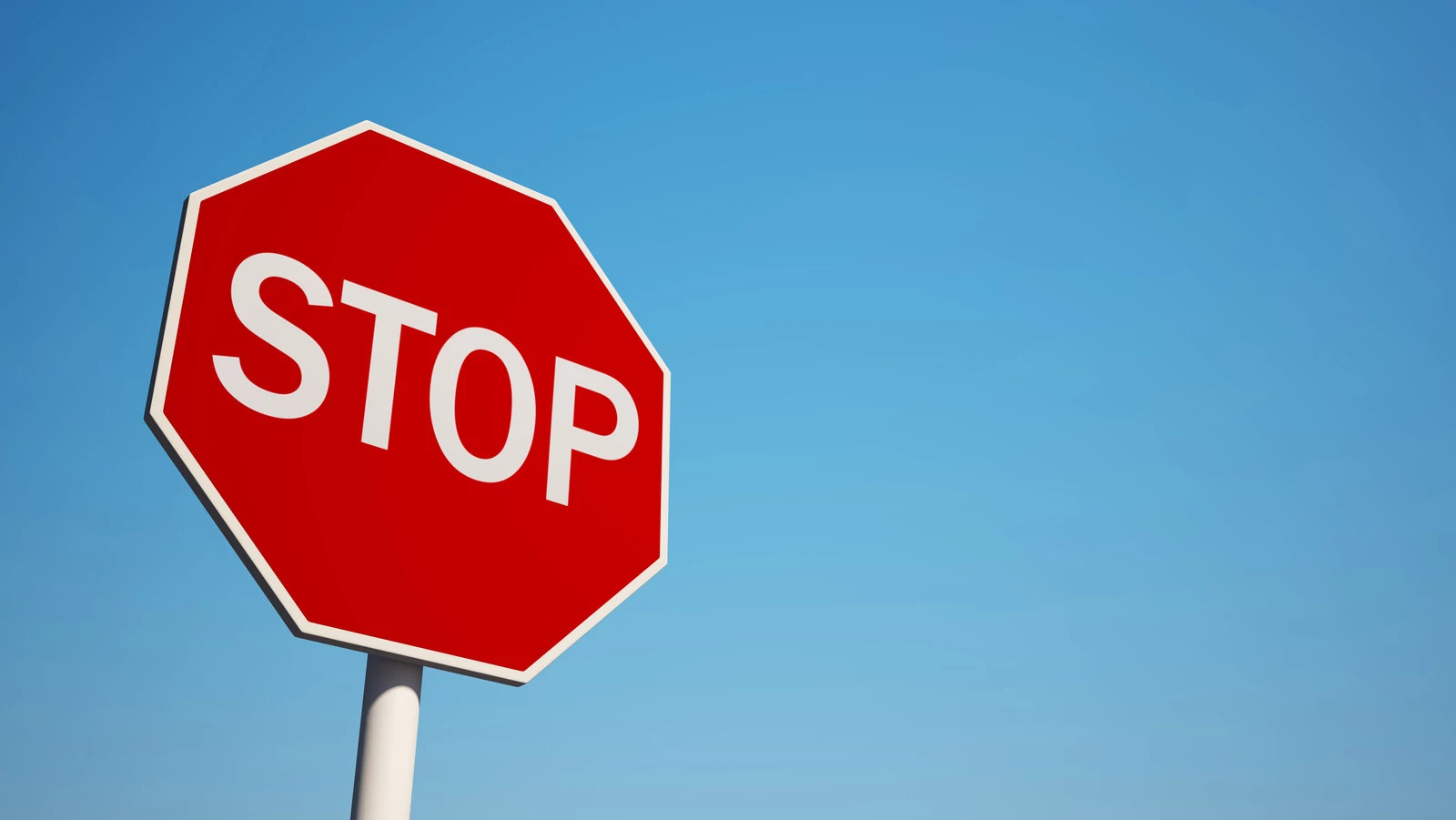 Stop Sign isolated on clean blue sky